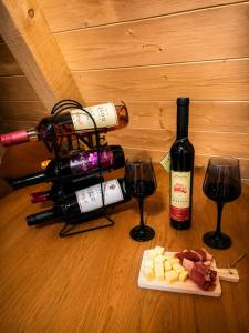 a table with a bottle of wine and wine glasses at Vikendica AS22 in Žabljak +5 photos