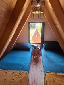 two beds in a attic room with a window at Vikendica AS22 in Žabljak