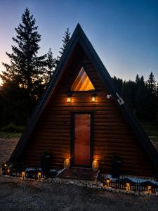 a small log cabin with lights in front of it at Vikendica AS22 in Žabljak
