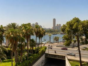 a bridge over a river with palm trees and a city at Garden El Tahrir Downtown Hotel in Cairo