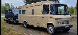 a tan van parked next to a black truck at Sleep inside a classic Volkswagen Westfalia or our legendary Mercedes Düdo overland cabin in central Svolvær Close to public showers and toilets NO PARKING in Svolvær