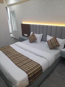 a bedroom with a large bed with two pillows at Hotel Rudrax in Waghoria +1 photo