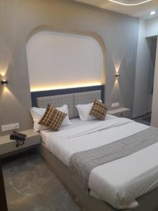 a bedroom with a large bed with pillows on it at Hotel Rudrax in Waghoria
