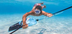 a man in the water on a board in the water at Hostal Fragata Puerto López in Puerto López