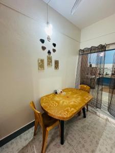 a dining room with a table and chairs and a window at NDM Homestay 2BHK in Sibsāgar