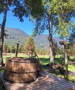 a wooden barrel on a wooden deck with trees at Rustika Tiny House in Pucón