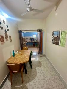 a dining room with a wooden table and a room with a ceiling at NDM Homestay 2BHK in Sibsāgar
