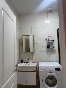 a white bathroom with a sink and a washing machine at Apartment in Gonio in Kvariati +10 photos