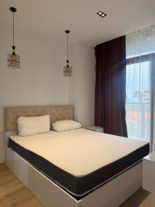 a bed in a bedroom with a large window at Apartment in Gonio in Kvariati