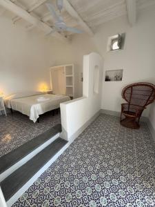 a bedroom with a bed and a chair in a room at Il Portico sul mare in Santa Marina Salina