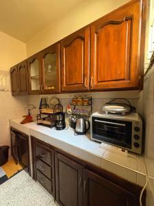 a kitchen with wooden cabinets and a microwave at maison souk agadir in Agadir
