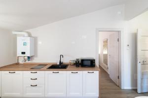 a kitchen with white cabinets and a sink at Chioggia Apartment in Chioggia