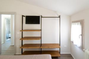 a bedroom with a book shelf and a tv at Chioggia Apartment in Chioggia +6 photos