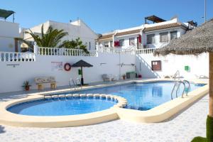a swimming pool in front of a villa at Super Cute Camposol 2 bed with Community Pool in Mazarrón +41 photos