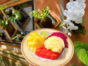 a bowl of fruit on a plate on a table at Purnama House Ubud in Ubud +29 photos