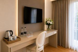 a desk with a white chair and a television on a wall at Purobaires Hotel Boutique in Buenos Aires