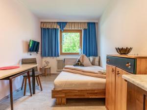 a room with a bed and a desk and a window at Hintermühltalhof in Itter