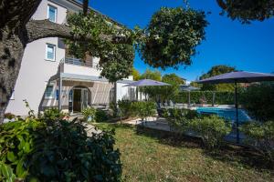 ein Haus mit Swimmingpool und Sonnenschirmen in der Unterkunft Villa Marea in Rovinj
