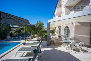 Eine Terrasse mit Tischen und Stühlen neben einem Pool in der Unterkunft Villa Marea in Rovinj