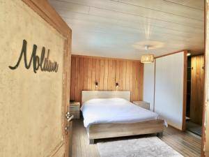 a bedroom with a bed in a wooden wall at Relais de Zoé in Gesves +38 photos