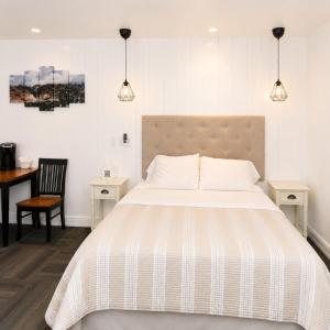 a bedroom with a bed and a desk and a table at Bybee's Steppingstone Motel in Tropic