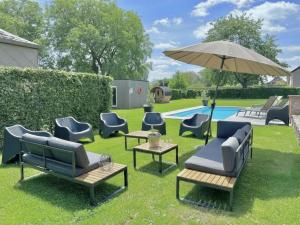 a yard with chairs and an umbrella and a pool at Relais de Zoé in Gesves