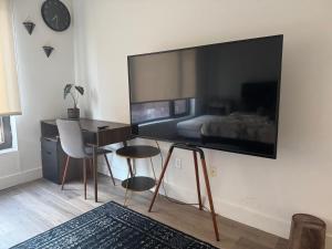 a bedroom with a desk and a large television on the wall at Cozy apt with City skyline rooftop in Union City