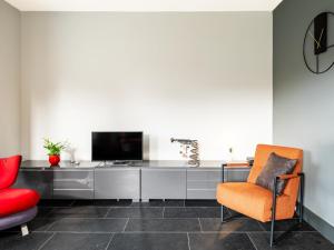 a living room with a television and a chair at La Terrasse in Sint-Idesbald