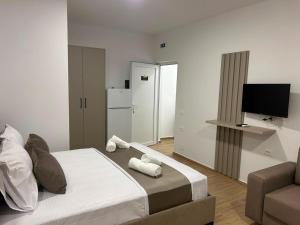 a bedroom with a bed and a couch and a television at Villa Dedi ,Borsh in Vane