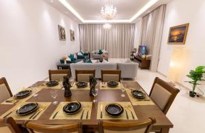 a dining room with a table and a living room at Al Dana H2O Beachfront Villa with a private pool, Al Dana Island Sharm Fujairah in Sharm