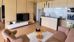 a living room with a couch and a tv and a kitchen at Denbi Eco Lodge in Greater Aman