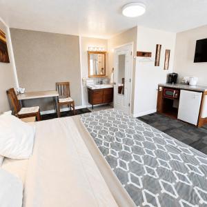 a bedroom with a bed and a kitchen and a sink at Bybee's Steppingstone Motel in Tropic