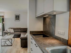 a kitchen and a living room with a couch at Lac Bleu 39 in Lacapelle-Marival