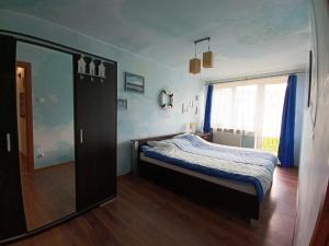 a bedroom with a bed and a large window at Apartament w Bieszczadach in Wołkowyja