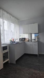 eine Küche mit weißen Schränken und einer Arbeitsplatte in der Unterkunft Relax Corner in Einigen