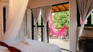 a bed with a stuffed animal on it in front of a window at Melo Capurganá Social Hostel in Capurganá +181 photos