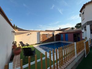 a backyard with a swimming pool and a wooden fence at La Era de Sandra in Sonseca