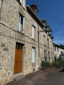a stone building with a wooden door on a street at T2 mansardé tout équipé in Limoges