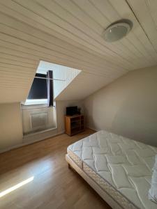 a bedroom with a white bed and a window at T2 mansardé tout équipé in Limoges