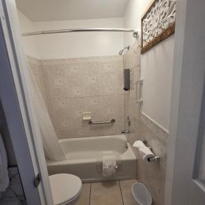 a small bathroom with a tub and a toilet at Bybee's Steppingstone Motel in Tropic +23 photos