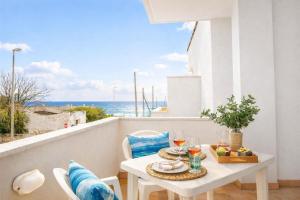 a table and chairs on a balcony with a view of the ocean at ONDA BLU-Appartamenti in Torre dell'Orso +17 photos