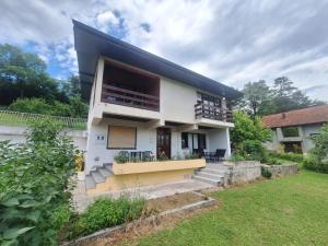 a white house with a balcony and a yard at Villa Tira in Jajce