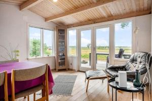 a dining room with a table and chairs and windows at 5020-Askeby-Faergensvaenge-18 in Askeby