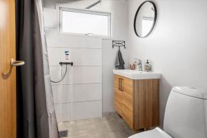 a bathroom with a shower and a sink and a mirror at 5020-Askeby-Faergensvaenge-18 in Askeby +19 photos