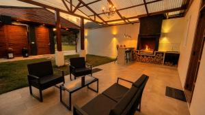 a patio with a fireplace and chairs and a table at OXALAND HAUs in Oxapampa