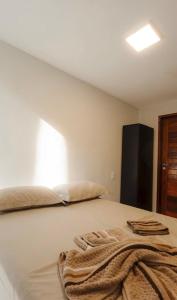 a bedroom with a bed with a blanket on it at Atins Ville Lençóis in Atins