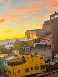a sunset over a city with a yellow building at Hotel Akuto's in Aparecida