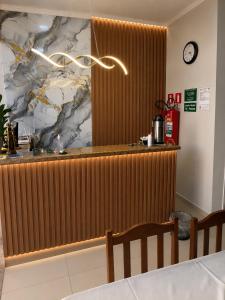 a counter in a restaurant with a clock on the wall at Hotel Akuto's in Aparecida