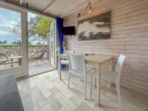 a dining room with a table and chairs on a balcony at Bleubird in Ellemeet