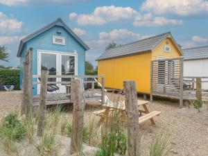 a blue and yellow house on the beach at Bleubird in Ellemeet